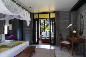 a bedroom with a bed and a living room at Anantara Lawana Koh Samui Resort in Chaweng