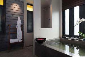 a bathroom with a tub and a sink and a chair at Anantara Lawana Koh Samui Resort in Chaweng