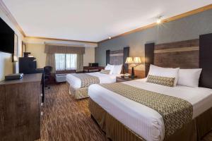 a hotel room with two beds and a flat screen tv at Baymont by Wyndham Pompton Plains/Wayne in Pompton Plains