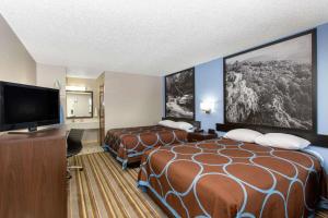 um quarto de hotel com duas camas e uma televisão de ecrã plano em Super 8 by Wyndham Malvern em Malvern