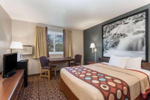 a hotel room with a bed and a desk at Super 8 by Wyndham Gillette in Gillette