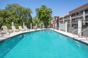 a swimming pool with lounge chairs and a building at Super 8 by Wyndham Austin University/Downtown Area in Austin