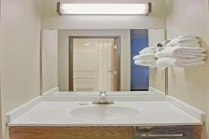a bathroom with a sink with a mirror and towels at Baymont Inn & Suites Richmond in Richmond