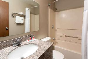 a bathroom with a sink and a toilet and a mirror at Super 8 by Wyndham Gillette in Gillette