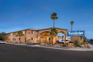 a hotel with palm trees in front of a building at Travelodge by Wyndham Lake Havasu in Lake Havasu City