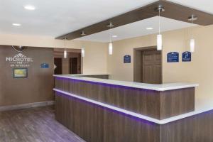 a hotel lobby with a reception counter with purple lighting at Microtel Inn & Suites by Wyndham Columbia Fort Jackson N in Columbia