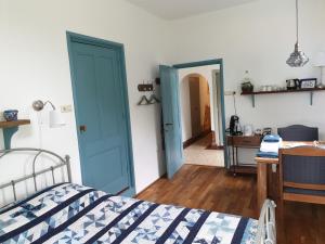 a bedroom with blue doors and a desk and a bed at Hunsingo Texel in De Cocksdorp