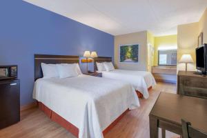 a hotel room with two beds and a television at Days Inn by Wyndham Grantville in Grantville