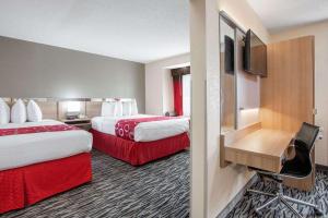 a hotel room with two beds and a flat screen tv at Microtel Inn & Suites by Wyndham Charleston in Charleston