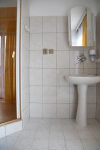a white bathroom with a sink and a shower at Resort Hotel Zvíkov in Zvíkovské Podhradí