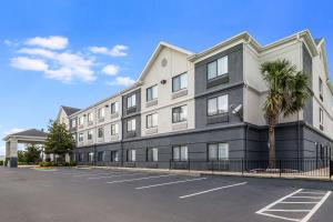 a large building with a palm tree in a parking lot at Quality Inn & Suites Augusta I-20 in Augusta