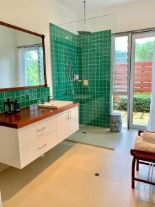 a bathroom with a sink and a shower with green tiles at Wilderness House in Margaret River Town