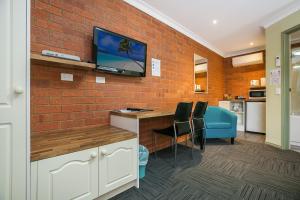 a room with a tv on a brick wall at Bendigo Goldfields Motor Inn in Bendigo