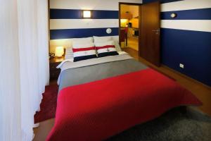 una camera da letto con un grande letto a strisce rosse e blu di Apartament Baltic Park Plaża 1.1.1 a Świnoujście