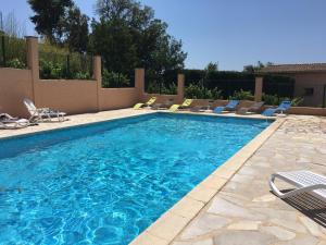 a swimming pool with chairs and a swimming pool at Les Oliviers in Grimaud