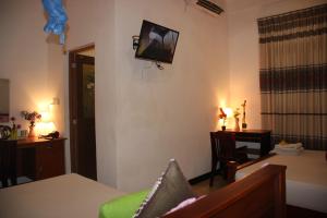 a living room with a television on the wall at Miheen Hotel & Resort - Anuradhapura in Mihintale