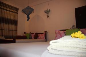 a bedroom with a bed and a living room with a couch at Miheen Hotel & Resort - Anuradhapura in Mihintale