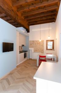 a kitchen and living room with white cabinets and a table at La dimora di Filippo in Cuneo