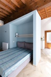 a bed in a room with blue walls and wooden ceilings at La dimora di Filippo in Cuneo