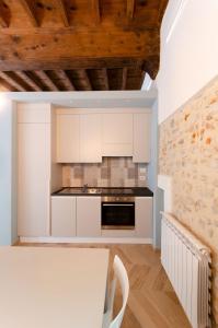 a kitchen with white cabinets and a stove top oven at La dimora di Filippo in Cuneo