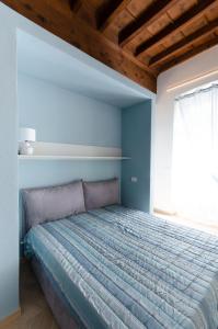 een slaapkamer met een bed met een blauwe muur bij La dimora di Filippo in Cuneo