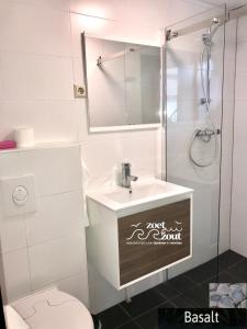 een badkamer met een wastafel, een toilet en een spiegel bij Holiday Home BASALT 6 p Amsterdam and the beach in Opmeer