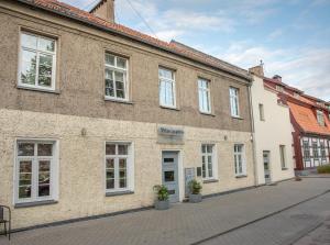 a large brick building with white windows on a street at Svečių Namai - Pilies Papėdėje in Klaipėda