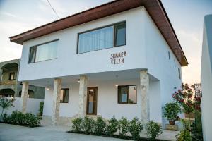 a white building with a sign that reads village hall at Summer Villa in Vama Veche