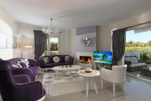 a living room with purple furniture and a fireplace at Aphrodite Luxury Villa Hersonissos in Hersonissos