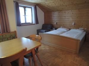 1 dormitorio con 1 cama, 1 mesa y 1 silla en Appartements Karin Mitten im Grünen, en Schoppernau