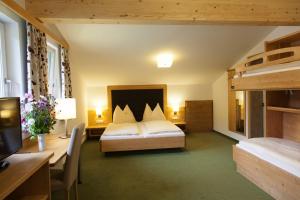 una camera da letto con un letto e una scrivania con un computer di Hotel Ennskraxblick a Kleinarl