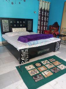 Cama en habitación con alfombra en el suelo en Sunita homestay en Agra