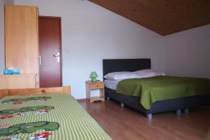 a bedroom with two beds and a wooden floor at Pokoje u Wojtka Charbrowo in Charbrowo