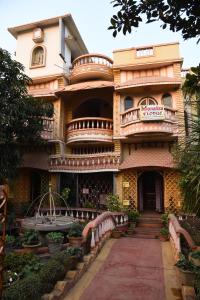 a large building with a staircase in front of it at Monalisa Lodge in Vishnupur