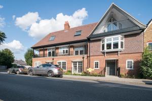 una gran casa de ladrillo con coches estacionados frente a ella en Hampden Apartments - The Diana, en Windsor
