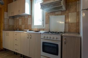 a kitchen with a stove and a window at Vila Maria Rustic Predeal in Predeal