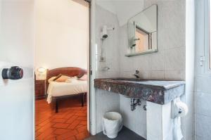 a bathroom with a sink and a bedroom with a bed at Hotel Costantini in Florence