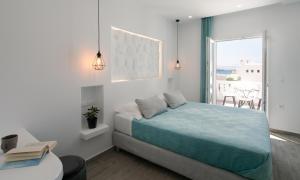 a bedroom with a bed and a table and a window at Iades Studios & Apartments in Agia Anna Naxos +67 photos