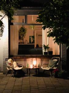 twee stoelen en een tafel met kaarsen voor een spiegel bij Appartement 'de Stadstuin' in Harderwijk