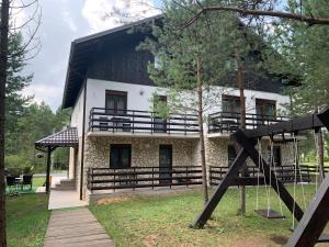 a house with a wooden walkway in front of it at Apartmani Zeder Plitvička jezera in Rudanovac