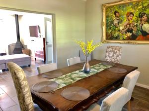 a dining room with a table and a painting on the wall at The Barn in Franschoek in Franschhoek