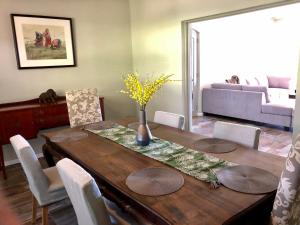 a dining room with a wooden table and a couch at The Barn in Franschoek in Franschhoek