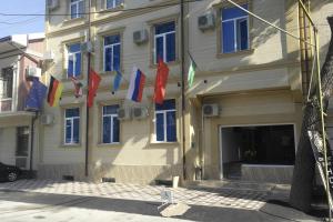 un edificio con banderas a un lado. en Orient Star Hotel, en Tashkent