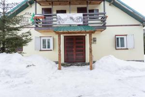 a house with a pile of snow in front of it at Vila Maria Rustic Predeal in Predeal