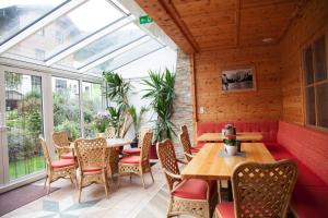 a conservatory with tables and chairs and a window at Hotel Ennskraxblick in Kleinarl