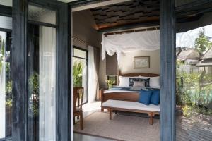 a bedroom with a bed on a porch at Anantara Lawana Koh Samui Resort in Chaweng