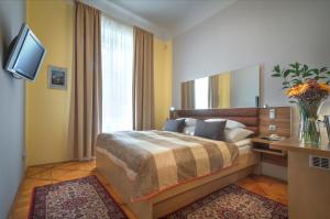 a bedroom with a large bed and a large window at Monastery Hotel in Prague