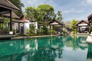 a swimming pool in front of a villa at Anantara Lawana Koh Samui Resort in Chaweng