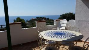 een tafel en stoelen op een balkon met uitzicht bij Appartamento Caminia in Stalettì