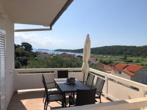 a patio with a table and chairs on a balcony at Apartmani Ankica in Kampor
